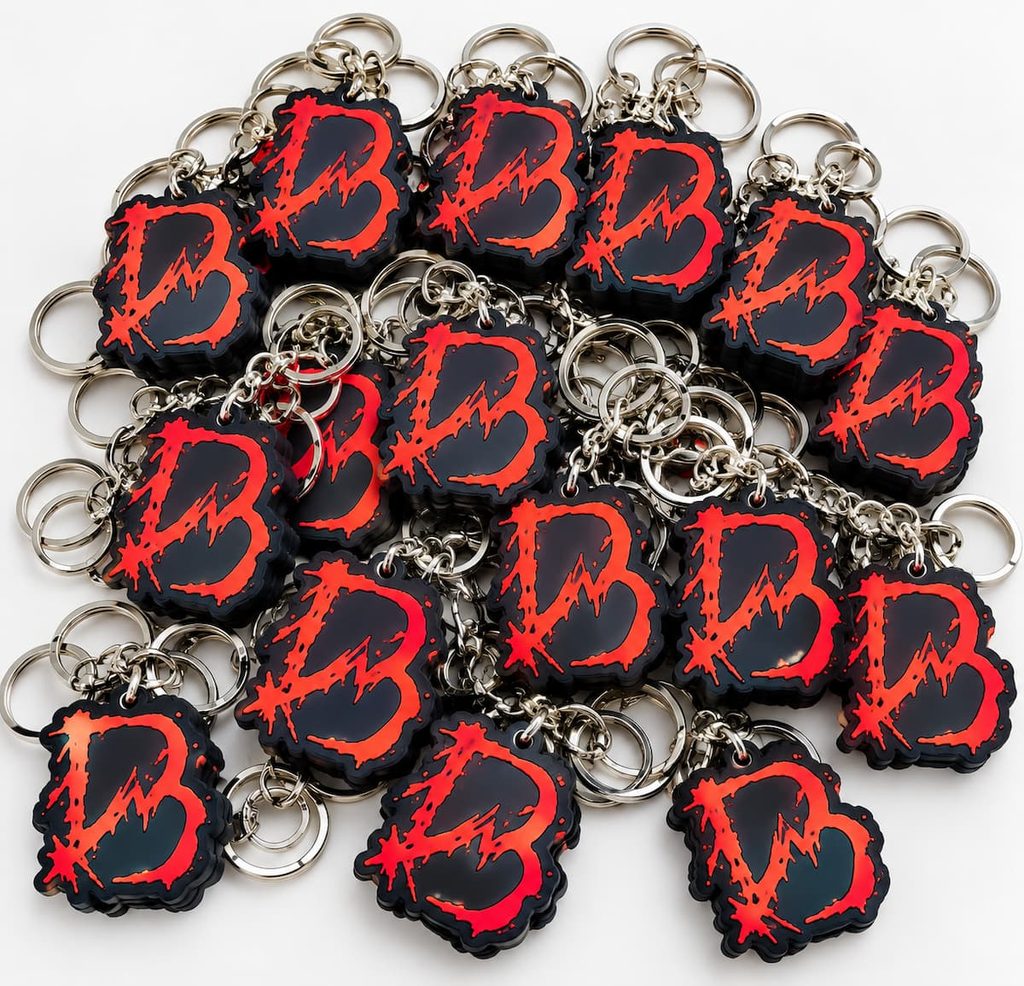Lote de llaveros de goma negros con logotipo rojo personalizados para Blackworks